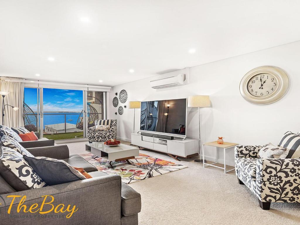 a living room with a couch and a tv at The Shoal 401 in Shoal Bay
