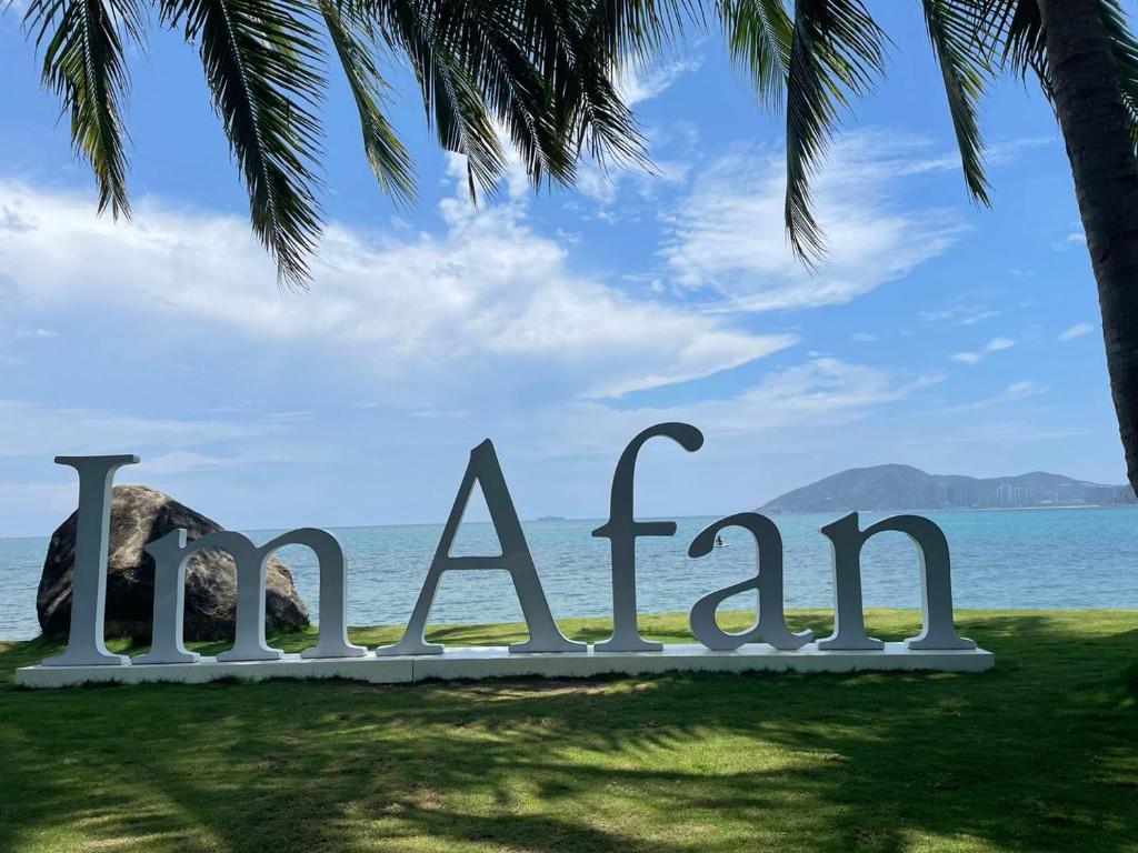 a sign for a beach with a palm tree at Mandarin Oriental, Sanya in Sanya