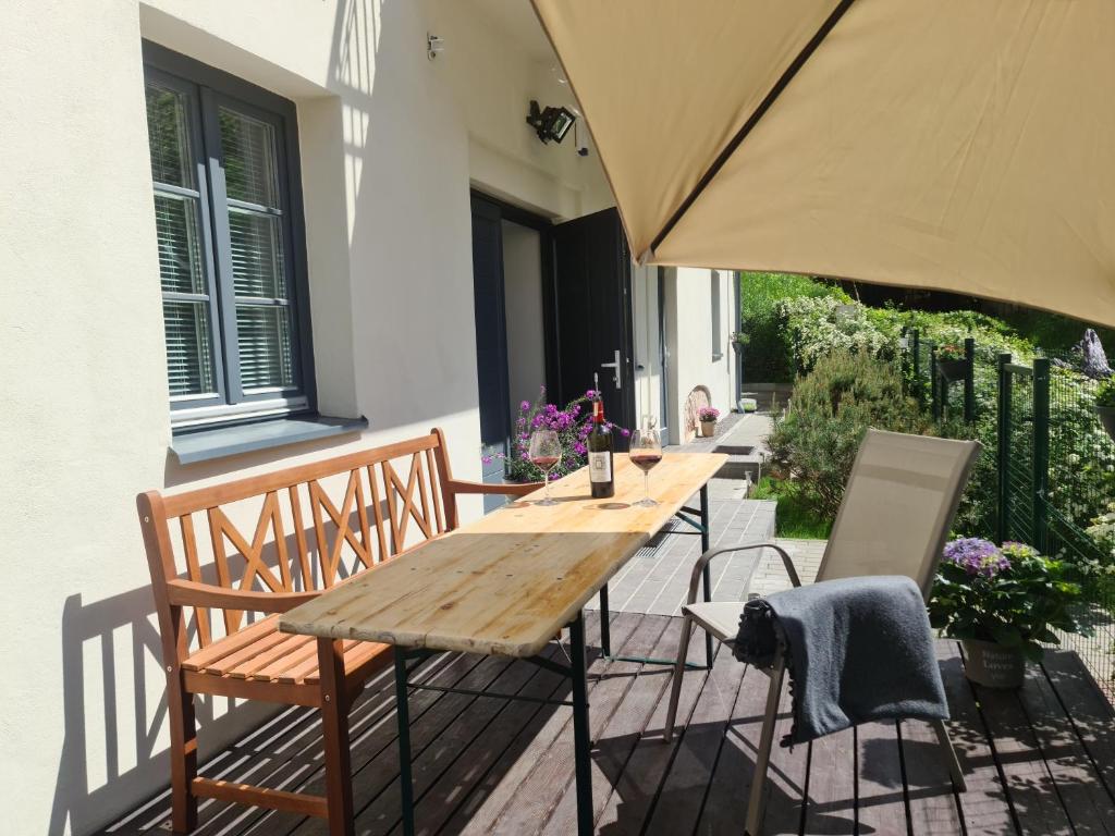 a wooden table and chairs on a patio with an umbrella at A perfect base to explore Vilnius! in Vilnius