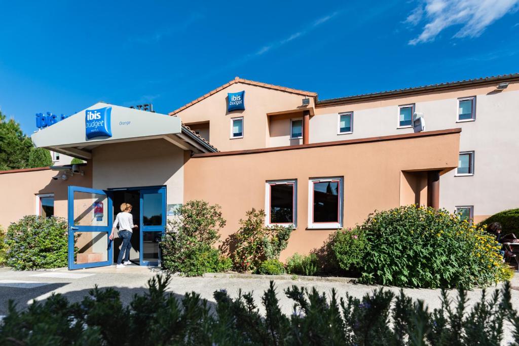 a woman standing outside of a building at ibis budget Orange Centre in Orange