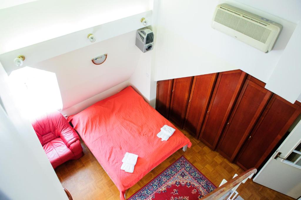 Camera piccola con letto rosso e divano rosso. di Apartments SOELEK - Vila Golf a Rogaška Slatina
