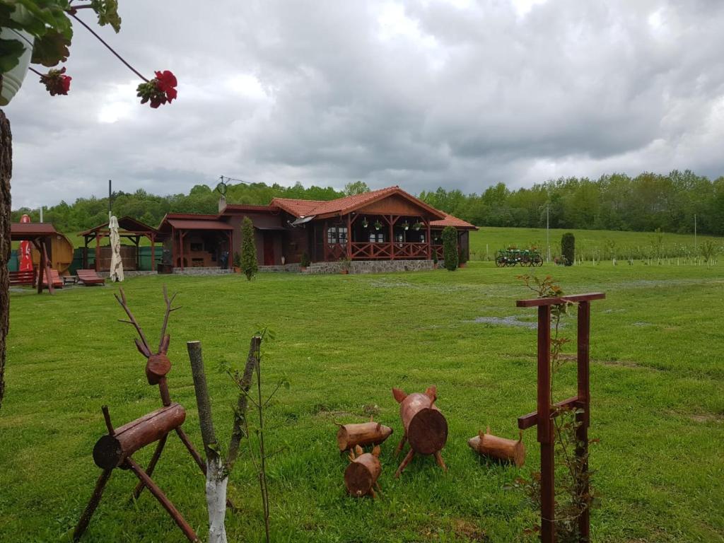 un grupo de animales en un campo frente a una casa en Cabana Dopca, en Racoşu de Jos