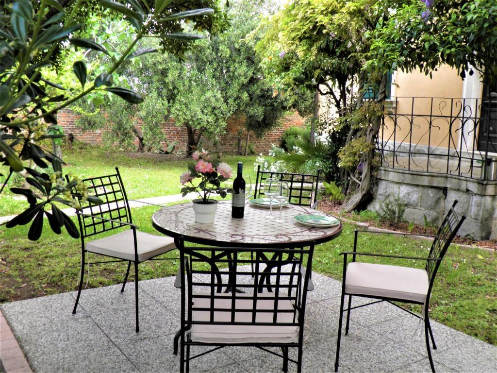 a table with four chairs and a bottle of wine at Beach City Pearls Apartments in Split