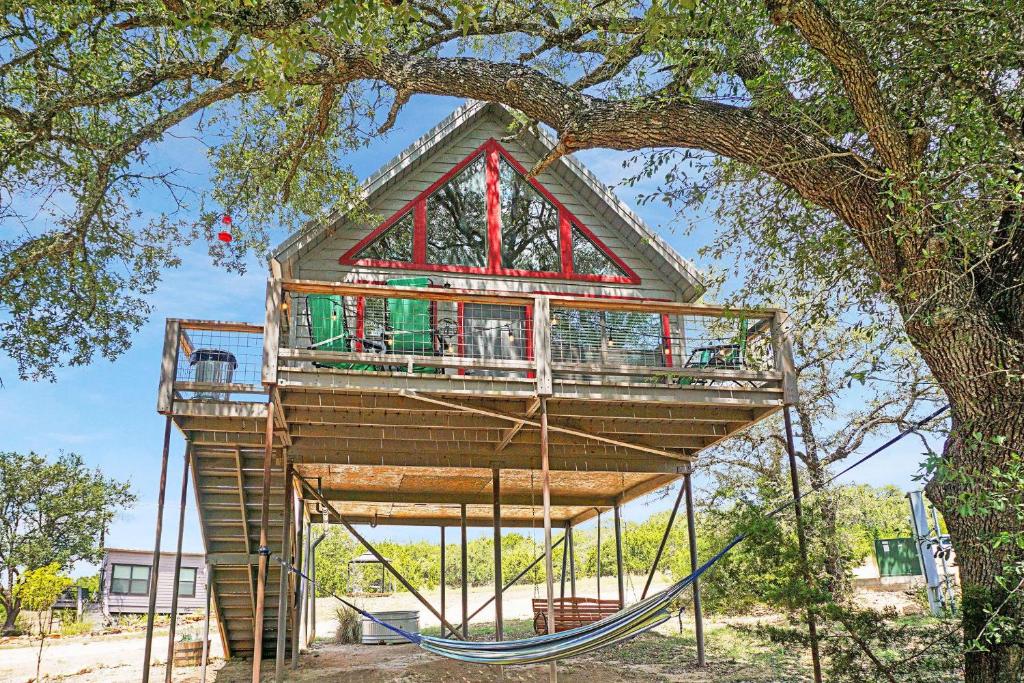 a tree house with a swing under a tree at Arbor House of Dripping Springs - Finch House in Dripping Springs