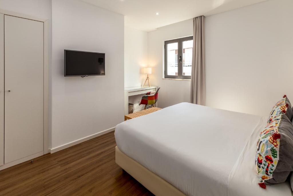 Cama ou camas em um quarto em Hotel Cidade de Olhão