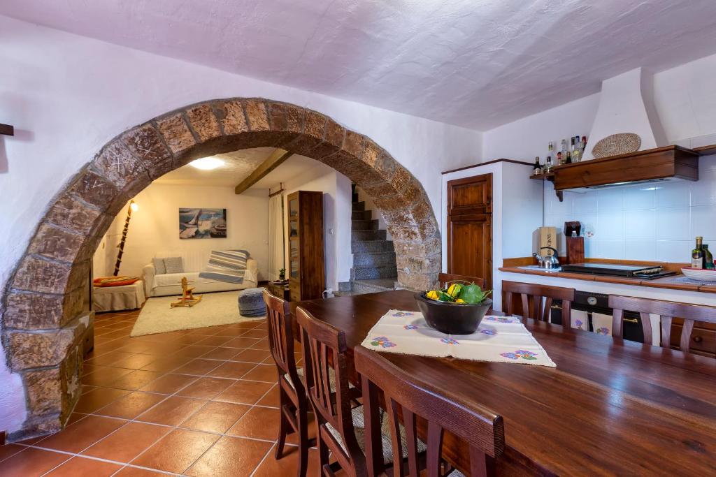 a kitchen and dining room with a stone archway at Esclusiva Dimora Storica nel cuore del Borgo Medievale---- Exclusive Historical House inside the Medieval Village in Castelsardo