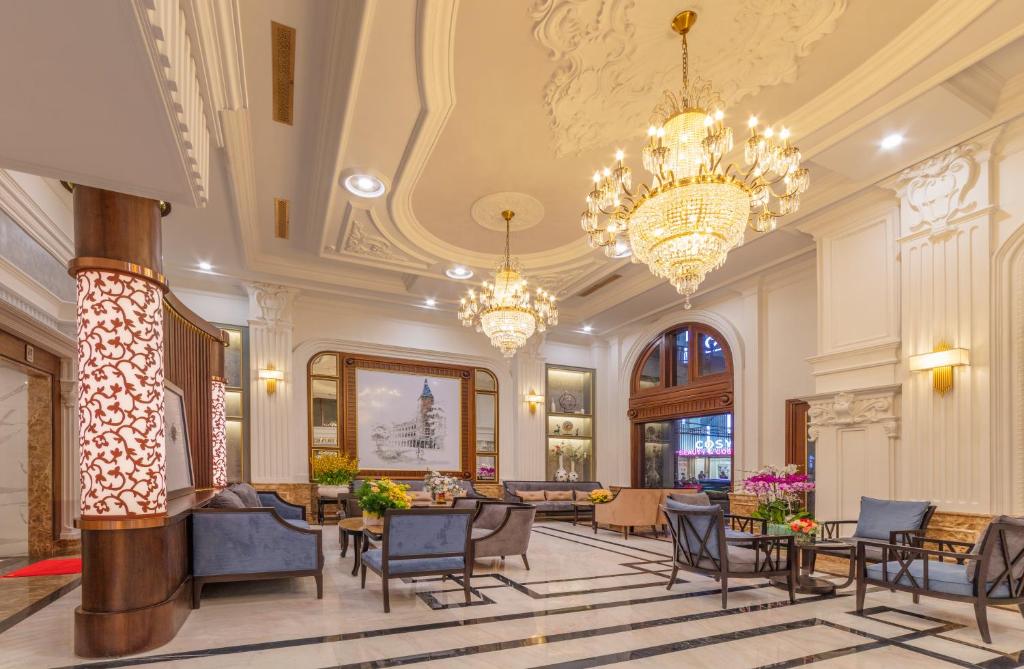 a lobby with chairs and tables and chandeliers at Marigold Hotel Dalat in Da Lat