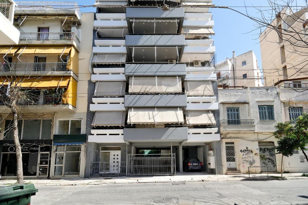 an apartment building with balconies on a city street at Trojan Affair Residence in Athens