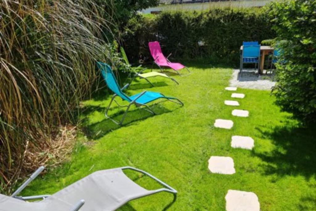 クルル・シュル・メールにあるTHE BOATSHED House-Premium vue Villeの芝生の椅子3脚と芝生の岩