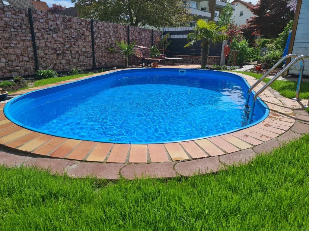 une grande piscine bleue entourée d'une terrasse en bois. dans l'établissement Ferienwohnung Rimbach, à Rimbach