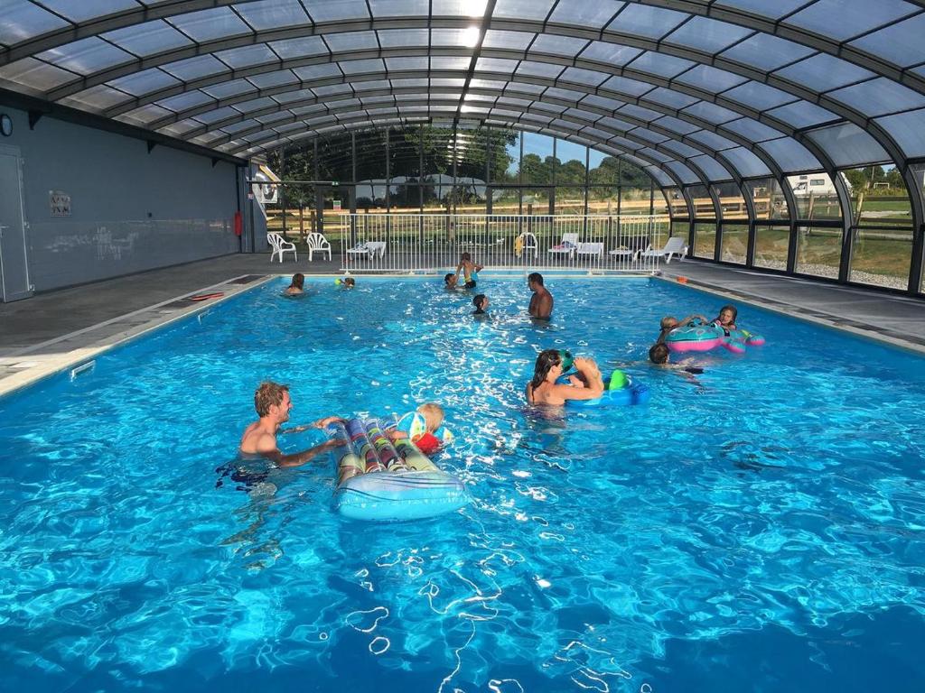 een groep mensen die in een zwembad spelen bij Safaritent Glamping Normandie in Longueville