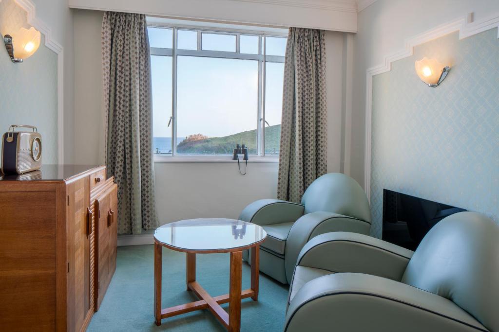 a waiting room with chairs and a table and a window at Burgh Island Hotel in Bigbury on Sea