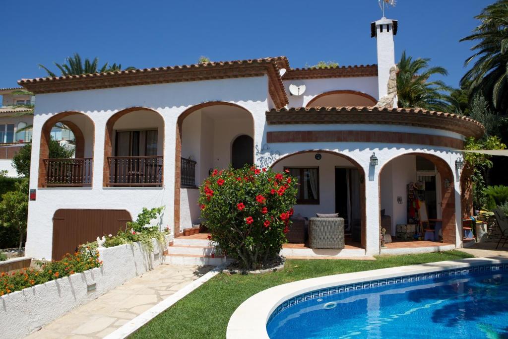 ein Haus mit Pool davor in der Unterkunft DAMA Villa con piscina privada in Miami Platja