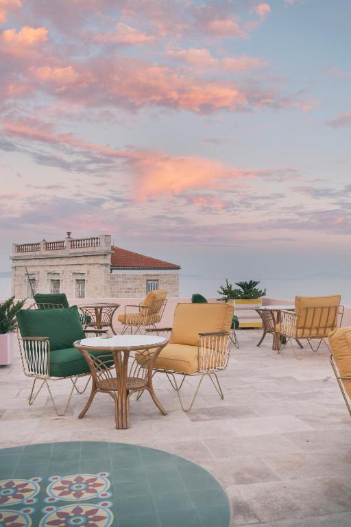 a group of chairs and tables on a roof at Aristide Hotel - Small Luxury Hotels of the World in Ermoupoli