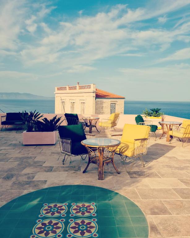 a group of chairs and tables on a patio at Aristide Hotel - Small Luxury Hotels of the World in Ermoupoli