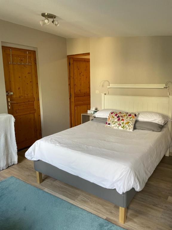 Les Sorbiers Barèges في باريج: غرفة نوم بسرير ابيض كبير عليها مخدة