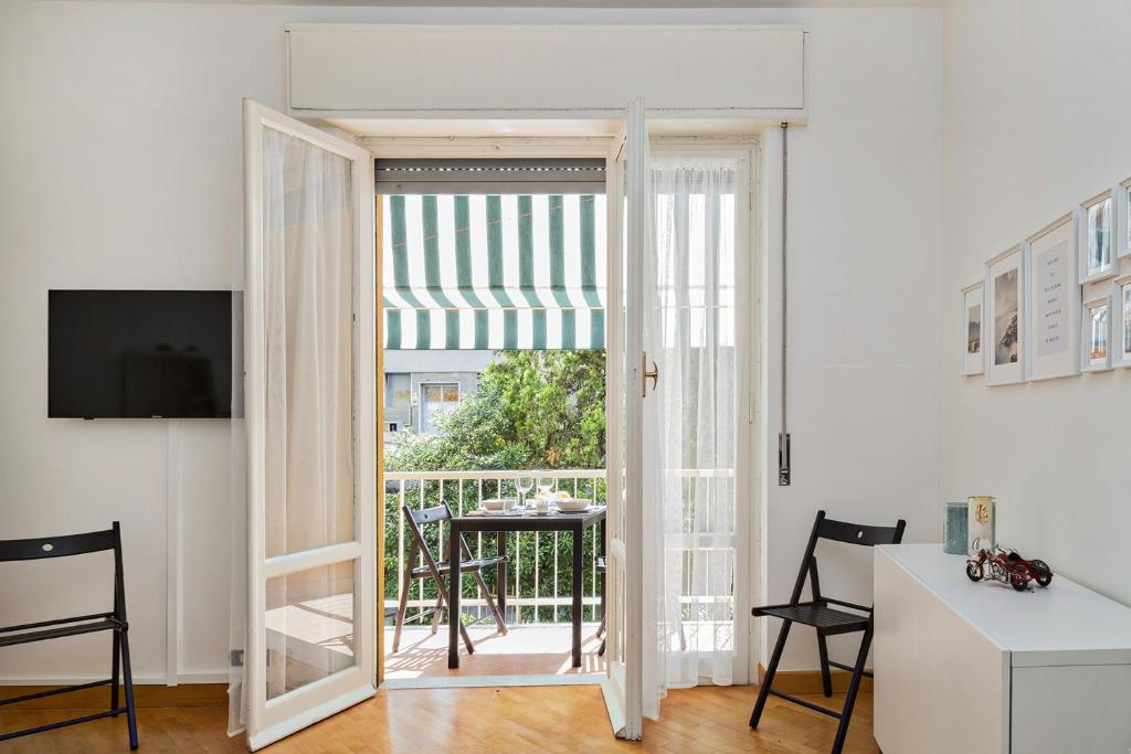 una camera con porta aperta su un tavolo e un balcone di Una Casa al Mare nel cuore di Rapallo by Wonderful Italy a Rapallo