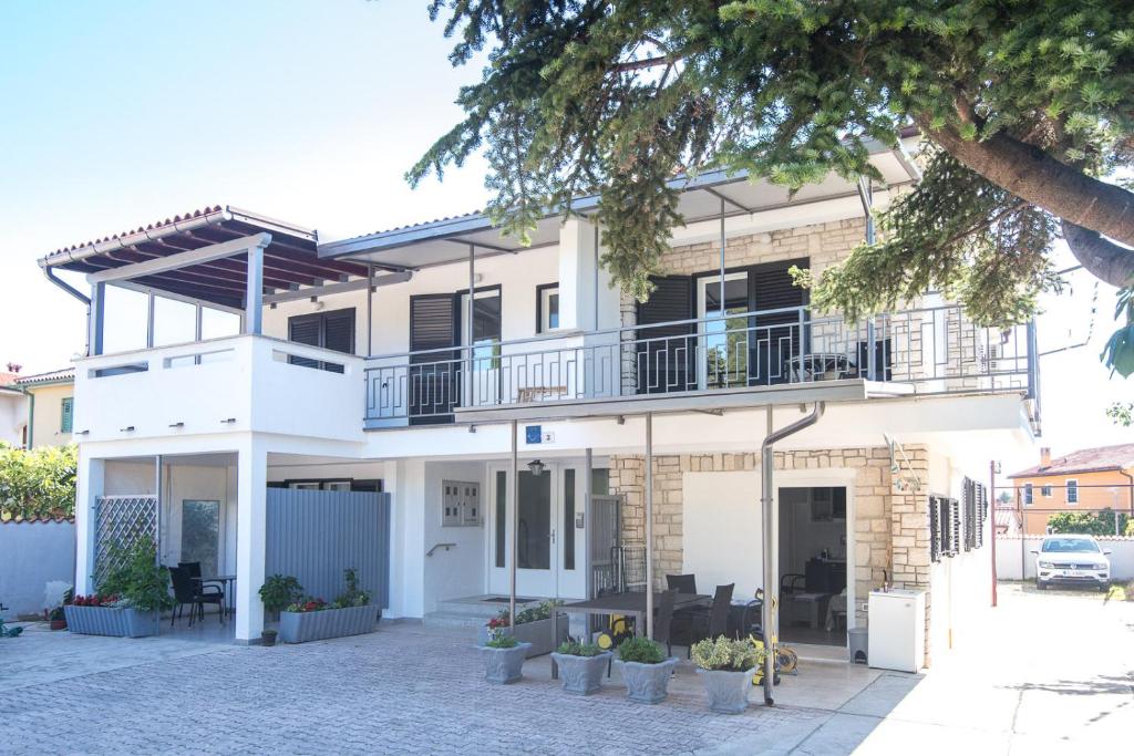 Großes weißes Haus mit Balkon in der Unterkunft Apartments Jasna 3 in Novigrad Istria