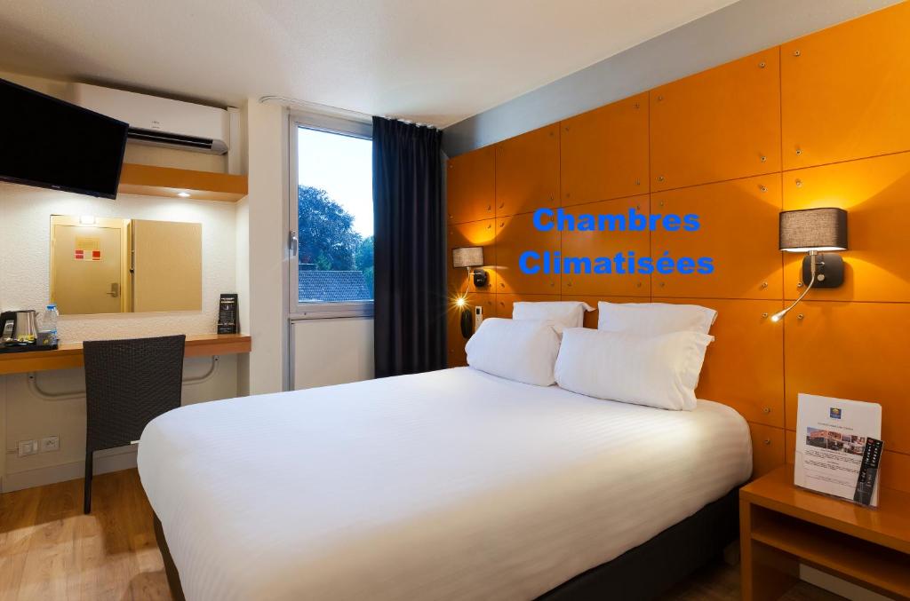 a hotel room with a large bed and a window at Comfort Hotel Lille L'Union in Tourcoing