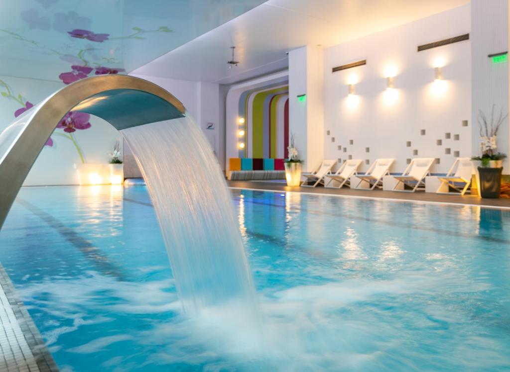 a pool with a water fountain in a hotel at Orhideea Residence & Spa in Bucharest