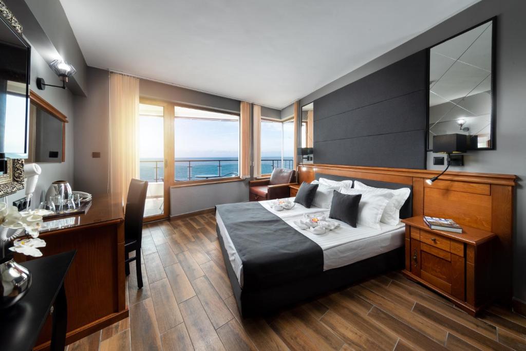 a hotel room with a bed and a desk at Petrov Family Hotel in Nesebar