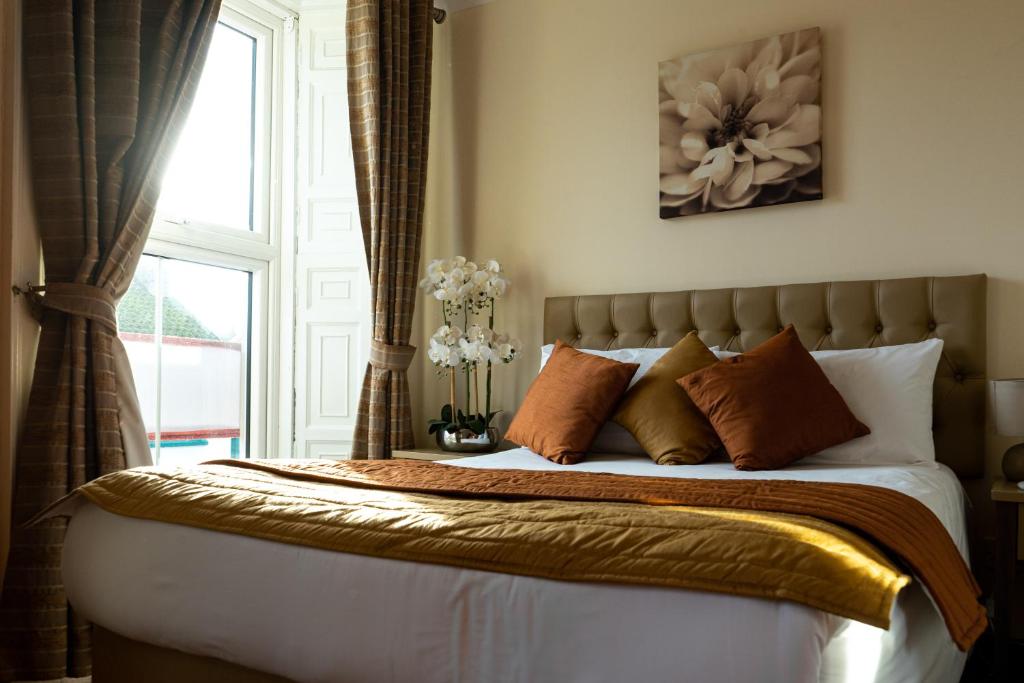 a bedroom with a bed with pillows and a window at Brogans Bar & Hotel in Trim