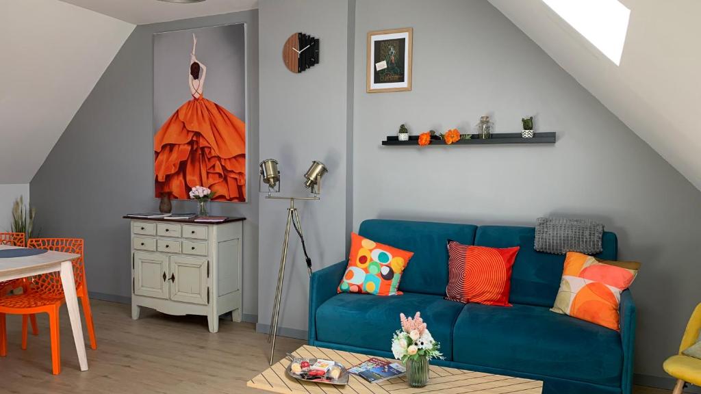 un soggiorno con un divano blu e un tavolo di SUPERLOGIS - Sous Les Toits - T2- 3étoiles - BLOIS-HYPERCENTRE 1 chambre 4 personnes a Blois