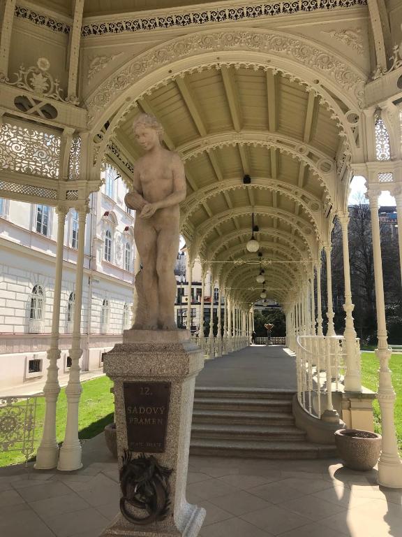 a statue of a man on a column under a building at Apartment Sadova in Karlovy Vary