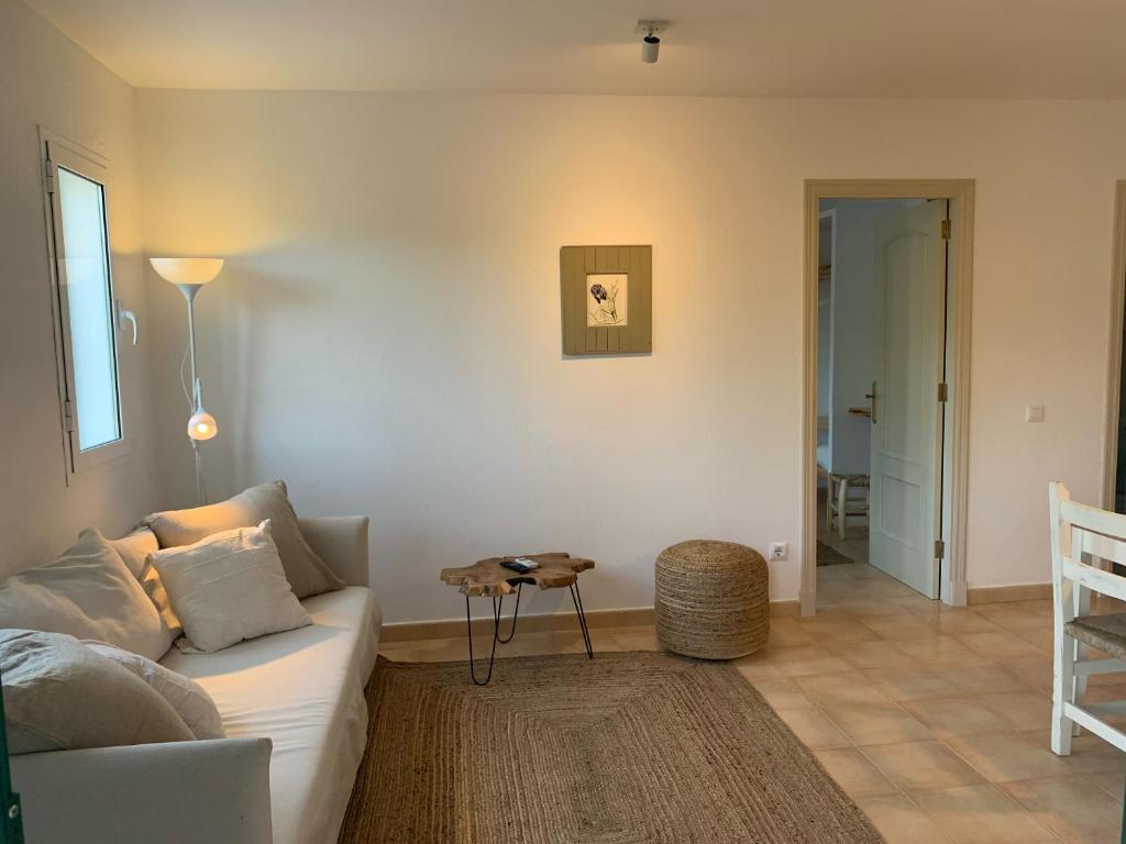 a living room with a couch and a table at Es Cucó in Cala Galdana