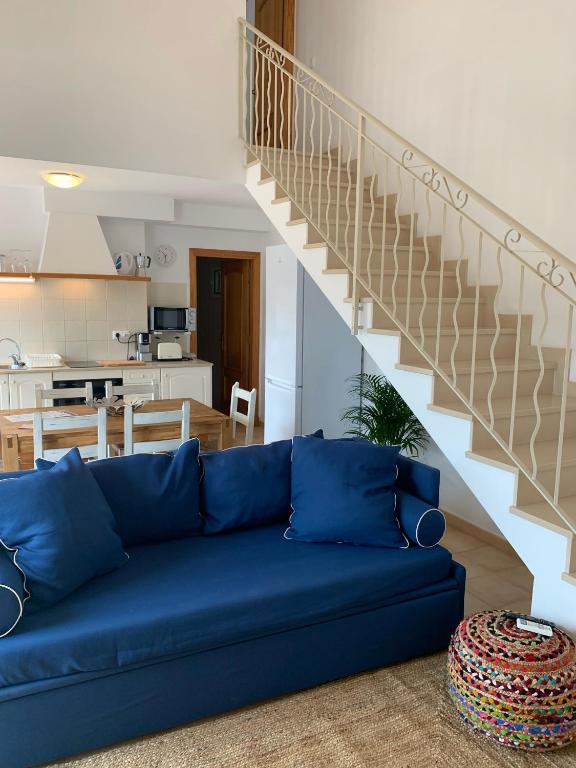 a blue couch in a living room with a staircase at Es Cucó in Cala Galdana