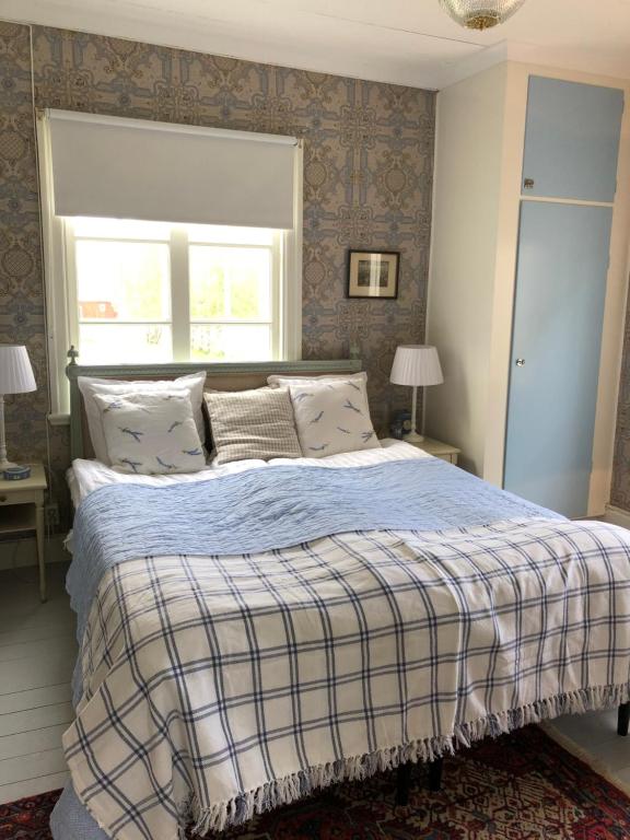 um quarto com uma cama grande e um cobertor xadrez em Träslottets B&B em Arbrå