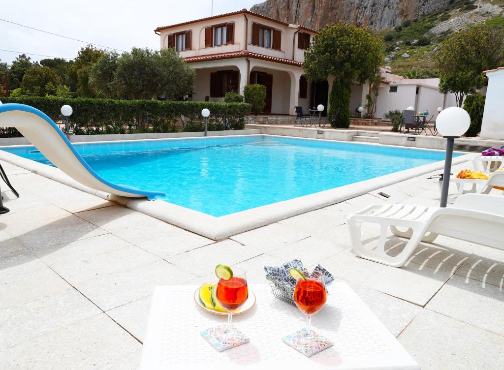 a villa with a swimming pool and a table with fruit on it at Villa Benny in San Vito lo Capo