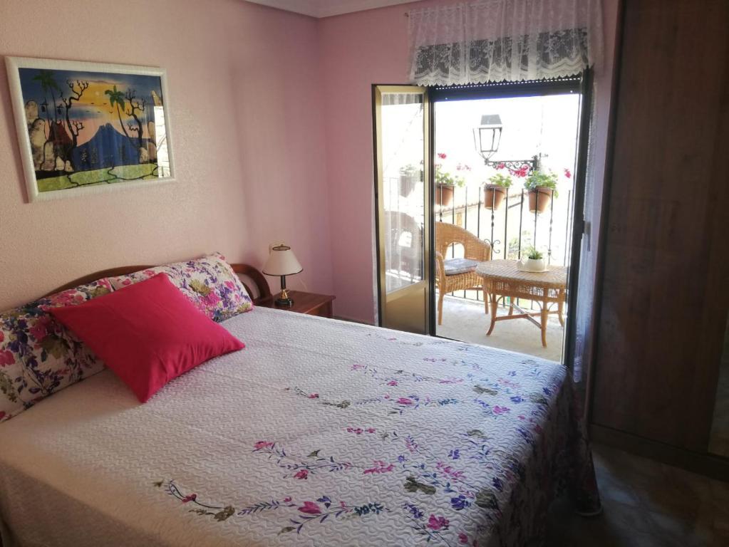 Un dormitorio con una cama con una almohada roja. en Casa Rural Pilarraña, en Ujué