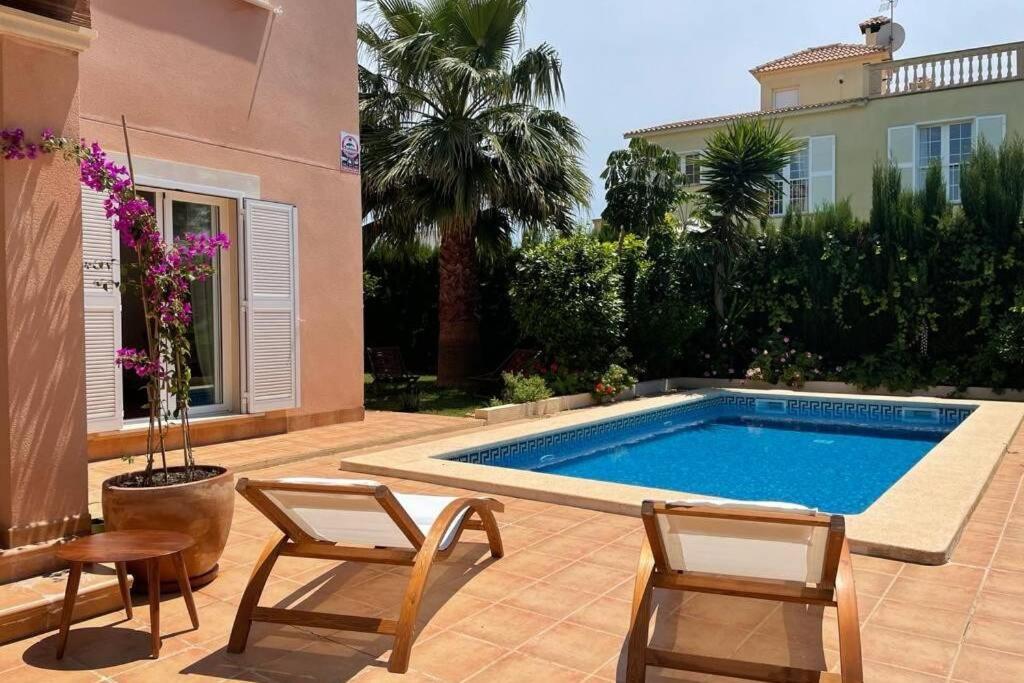 una piscina in un cortile con sedie e una casa di Casa Mar Blau - mediterranean house a Puigderrós