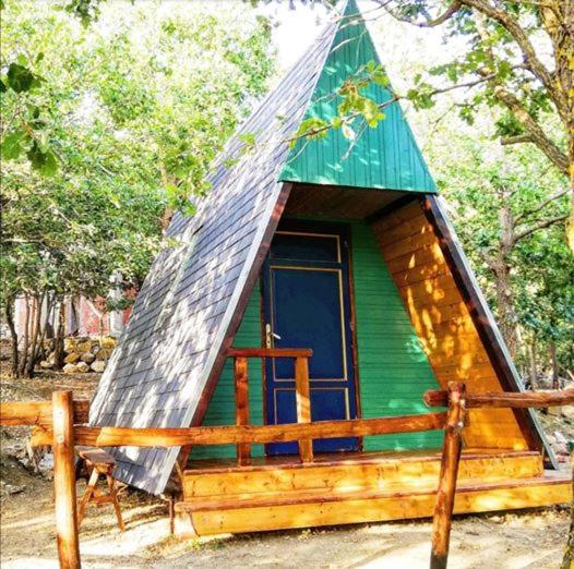 a small green cabin with a pyramid roof at HAPPY GLAMPING MADONIE in Polizzi Generosa