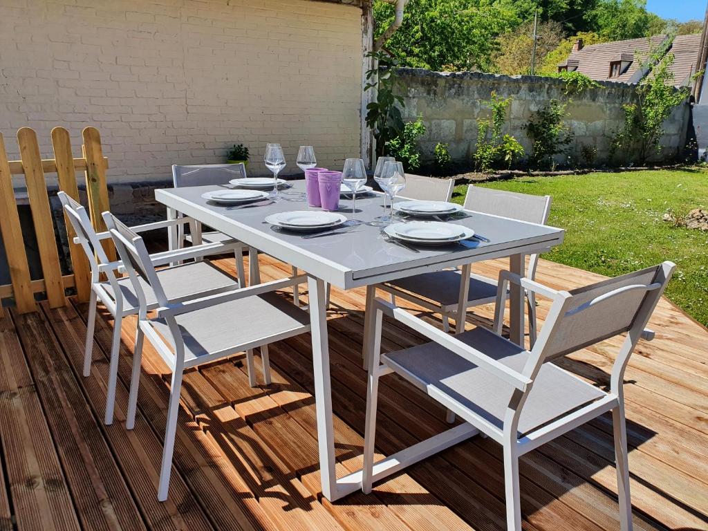a white dining table and chairs on a deck at Gîte de Palesne - Pierrefonds in Pierrefonds