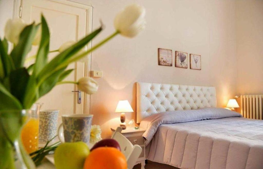 a bedroom with a bed and a table with a plant at hotel lisà in Viareggio