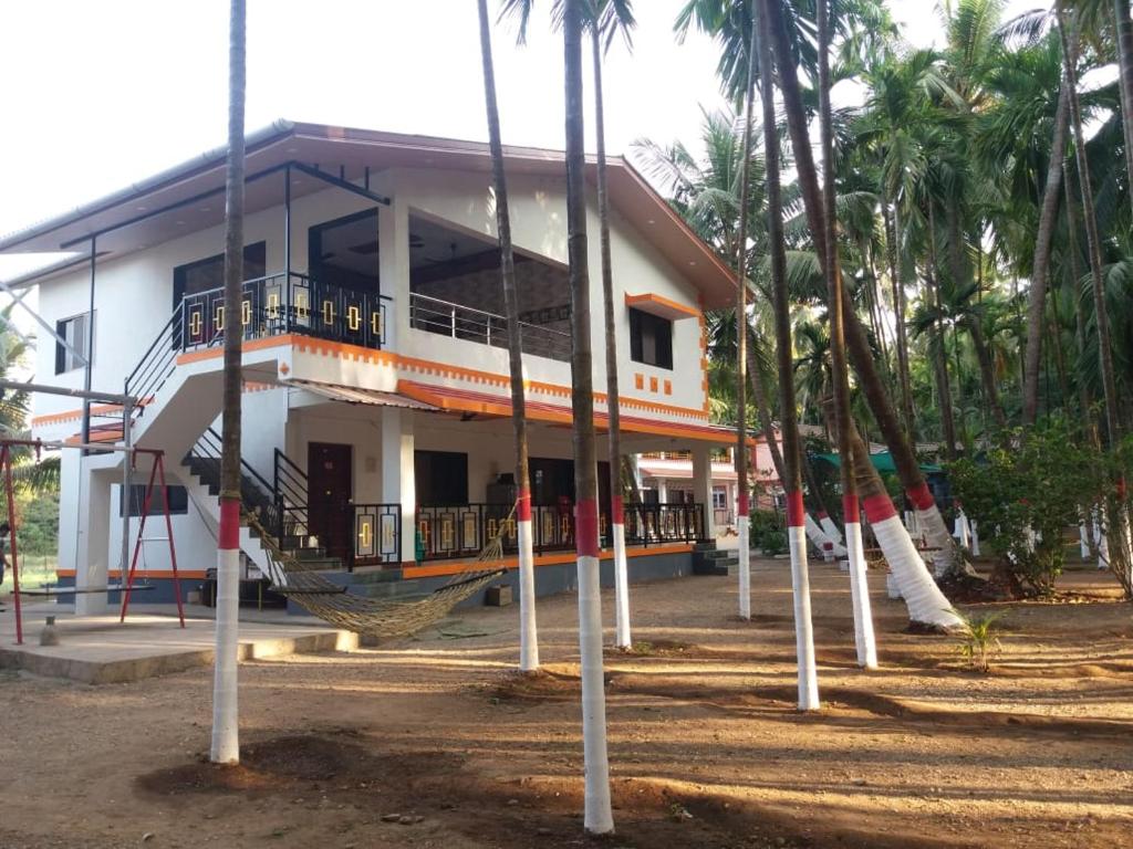 ein Gebäude mit Palmen davor in der Unterkunft Mill House in Alibag