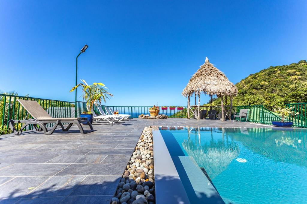 una piscina con vista al mar en Villa douillette à Deshaies – Vue sur la mer et la montagne - 96 m², en Deshaies