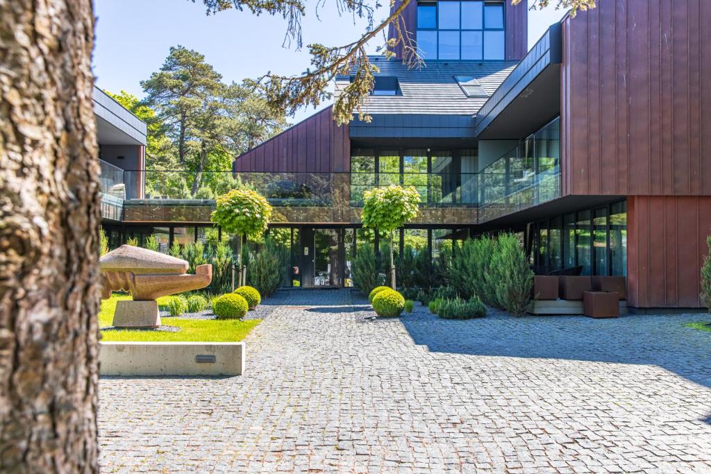 a building with a stone pathway in front of a building at Cuprum Poilsis in Palanga