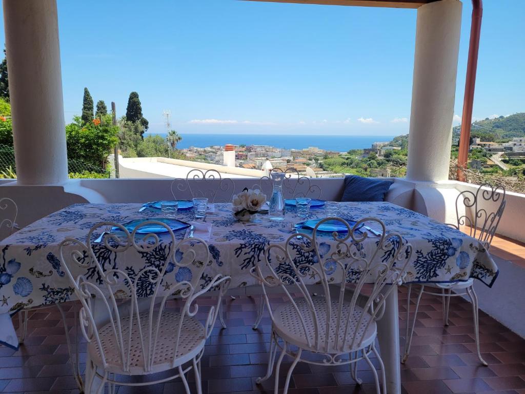 a table on a balcony with a view of the ocean at Casa Eolie relax in Lipari