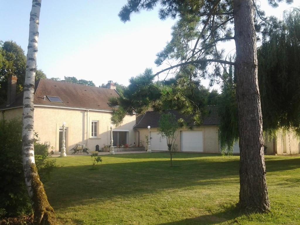 ein großes weißes Haus mit einem Hof mit Bäumen in der Unterkunft LA BONNE ADRESSE 