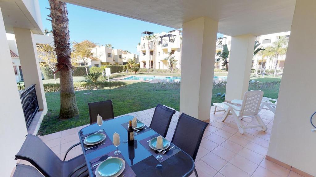 een blauwe tafel en stoelen op een patio met een zwembad bij Modern Apt - A Murcia Holiday Rentals Property in Los Alcázares