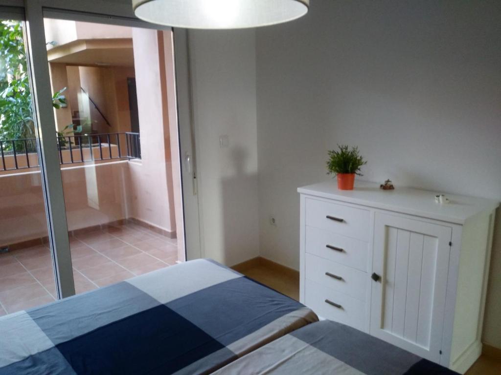 1 dormitorio con 1 cama, vestidor y balcón en Casa Germeau - A Murcia Holiday Rentals Property, en Torre-Pacheco