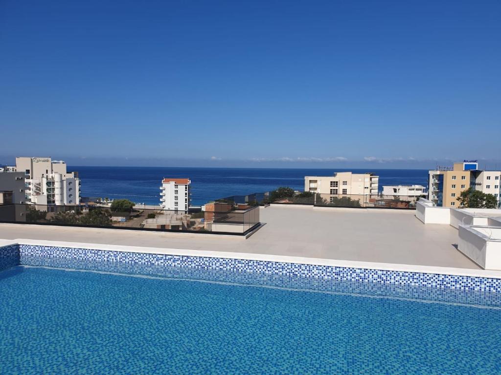 a swimming pool on top of a building with the ocean at Apartmani Aida in Dobra Voda