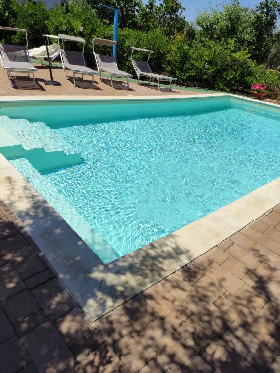 莫諾波利的住宿－B&B Oceano，庭院内带椅子的游泳池