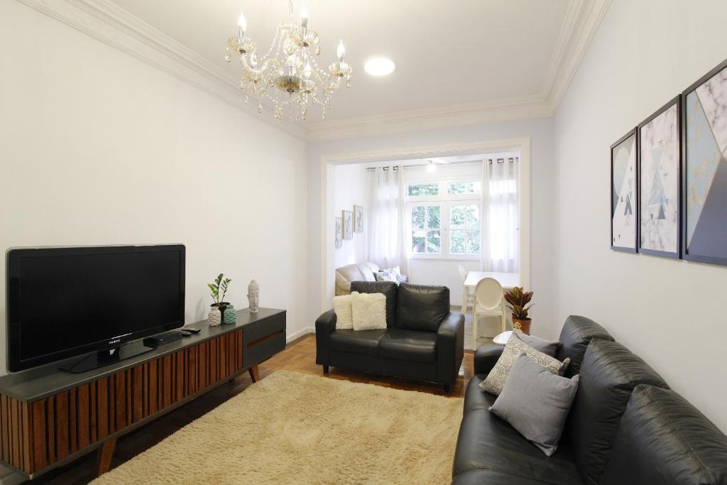 a living room with a television and a couch at Lindo em Copacabana - Quartos confortáveis - A306 Z3 in Rio de Janeiro