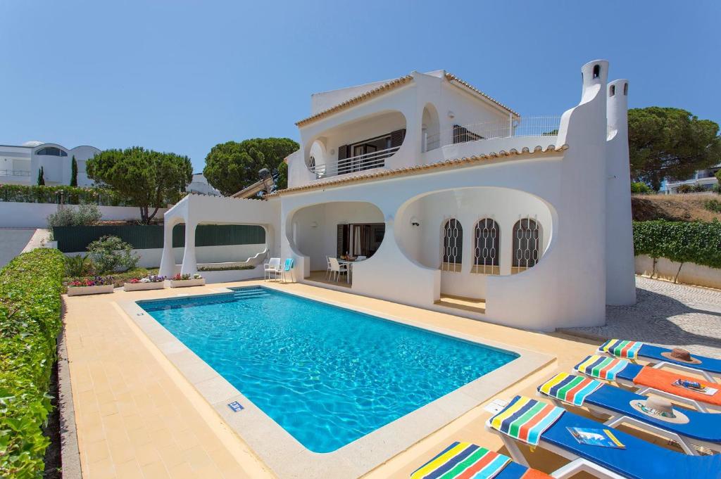 une villa avec une piscine en face d'une maison dans l'établissement Villa Medeira by Villa Plus, à Albufeira