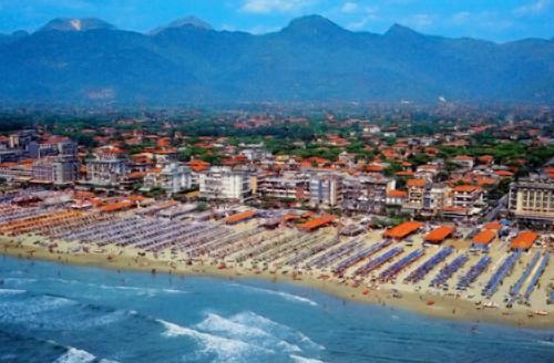 eine Luftansicht auf einen Strand mit Gebäuden und das Meer in der Unterkunft Hotel Montecarlo in Lido di Camaiore