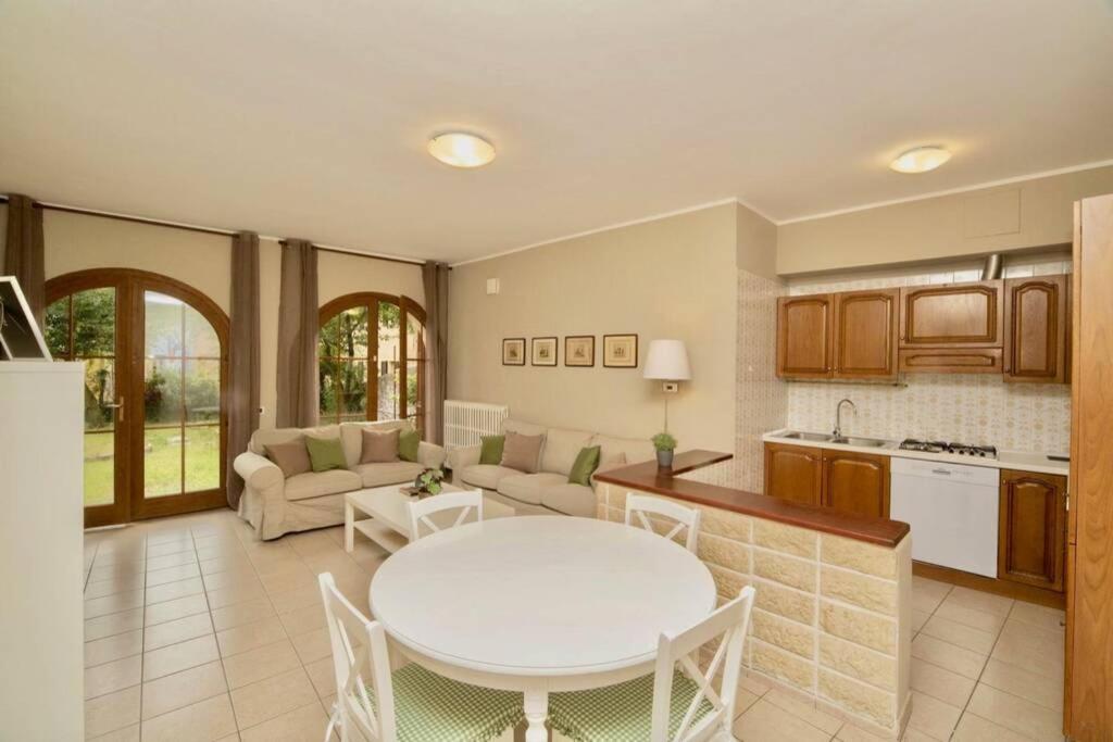 una cucina e un soggiorno con tavolo bianco e tavolo di Contempora Apartments - Ca' Brenta Garden a San Fedele Intelvi